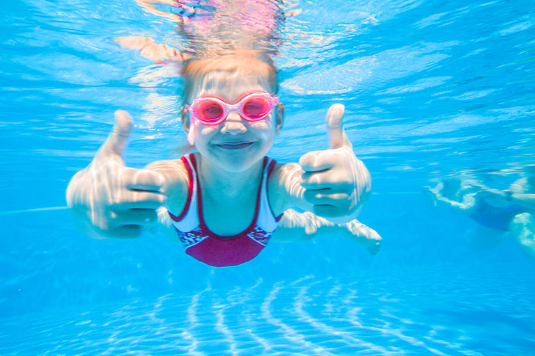 Fillette heureuse dans l'eau claire